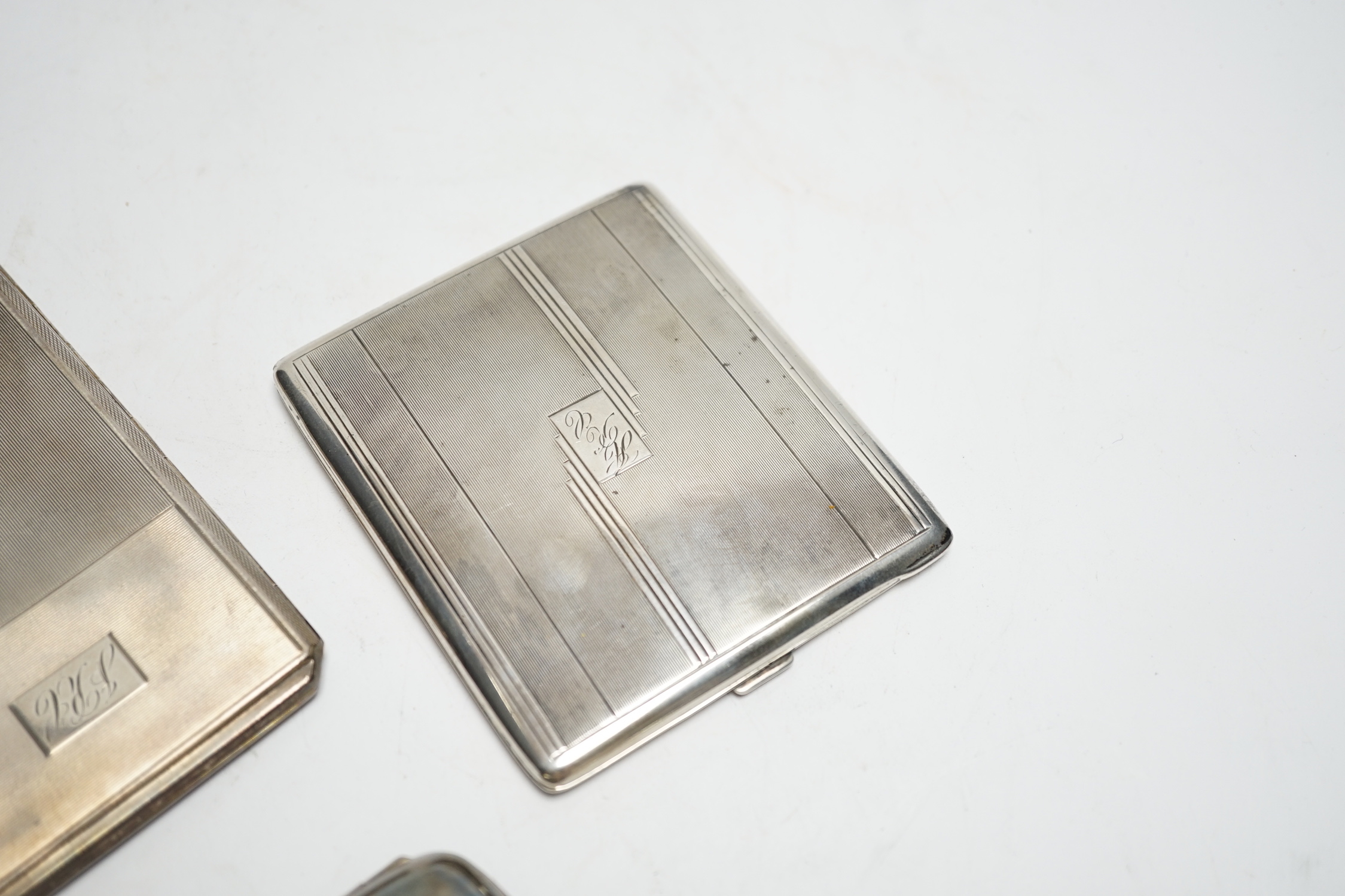 Three silver cigarette cases, including two Art Deco, largest 11.4cm.